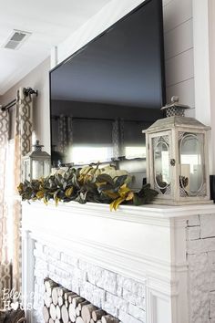 a flat screen tv mounted on top of a white mantle in front of a fireplace