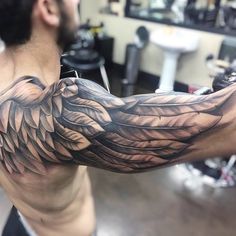 a man with a tattoo on his arm has an eagle design on it's arm