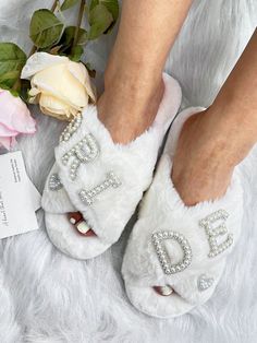 a close up of a person's feet wearing white slippers