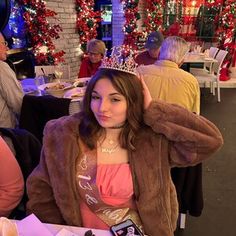 a woman wearing a tiara sitting at a table