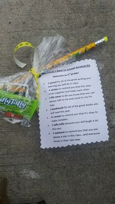 a note, pen and candy wrapped in plastic on the ground next to a key