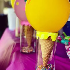 three ice cream cones with sprinkles in them on a purple table cloth