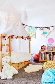 a child's bedroom with a canopy bed and stuffed animals on the rugs