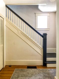 an empty room with stairs and carpet on the floor, in front of a door