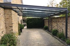 an outdoor patio with brick walls and a pergolated walkway leading to the front door