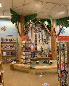 the children's book store has many books on shelves and is decorated with trees