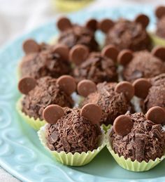 chocolate cupcakes with mickey mouse decorations on a blue and white plate, ready to be eaten