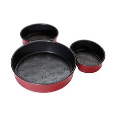 three red pans with mickey mouse designs on them are sitting next to each other