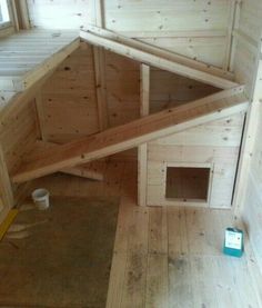 a dog house built into the side of a wall with wood planks on it