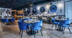 a restaurant with blue chairs and wooden floors