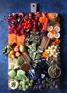 an assortment of fruits and vegetables laid out on a cutting board