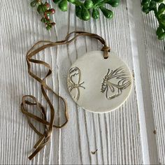 a ceramic ornament with an image of a bird on it next to some plants