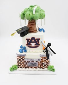 a cake made to look like a tree with graduation caps on top and other items around it