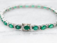 This stunning bracelet will add a touch of elegance and sophistication to any outfit. Crafted with white gold and embellished with sparkling emeralds and diamonds, this bracelet is perfect for any occasion. Show off your unique style with this exquisite piece!*Please note, that some of the stones have surface cavities, and the piece has been priced accordingly.Metal: 14K White GoldGem: Emeralds totaling 6.00 CaratsGem Measurements: 5.1 x 4.1 mm, OvalAccents: 48 Diamonds totaling .60 Carats, SI in Clarity, G-I in ColorLength: 7 InchesMarks: "14K 585 D079 E790" Stamped on the clasp Diamond Tennis Bracelet, Tennis Bracelet Diamond, Tennis Bracelet, Cavities, Unique Style, Emerald, Tennis, Diamonds, White Gold