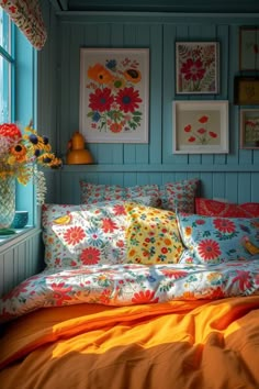 a bed sitting under a window next to a vase with flowers on top of it