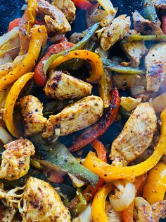 chicken fajita with peppers and onions on a blue grilling pan, ready to be cooked