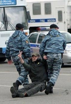 a man laying on the ground in front of two police officers