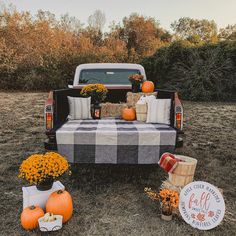 the truck is decorated with pumpkins and other fall decorations for decorationating it's bed