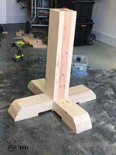 a wooden object sitting on top of a floor in a room with tools and other items