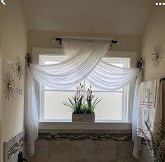 a bathroom with a tub, window and plants in the bathtub next to it