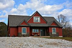 a red house sitting on top of a gravel covered field