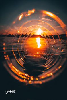 the sun is setting over water with bubbles in it