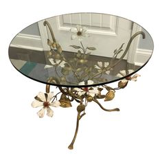 a glass table with flowers on it in front of a door