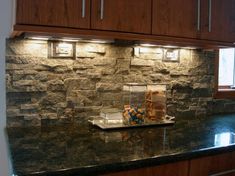 a kitchen counter with some food on top of it and lights above the countertop