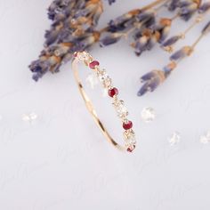 a close up of a bracelet with flowers in the background