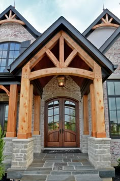 the front entrance to a large home with wood trimming