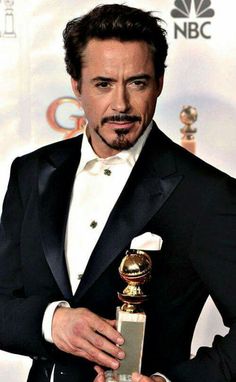 the actor is holding an award in his hand