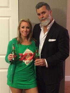 a man and woman posing for a photo while holding beer bottles