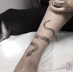 a woman's arm with a snake tattoo on the left side of her forearm