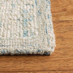 a close up view of a rug on the floor with blue and white colors in it