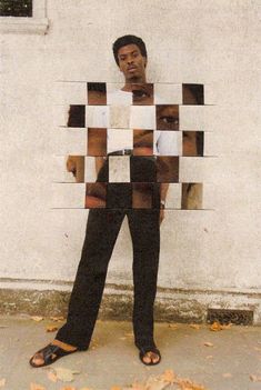 a man standing in front of a white wall with squares on it