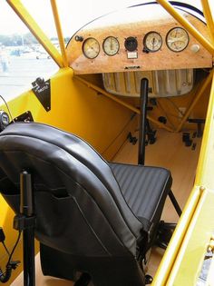 the cockpit of an old yellow airplane with gauges on it's back end