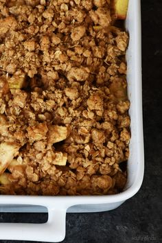 a casserole dish with apples and crumbs in it