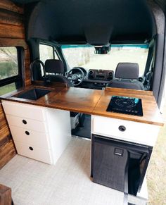 the interior of a camper with an oven and sink