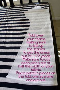 a black and white striped bed spread with pink writing on it that says fold over your fabric, making sure to line up the strips