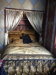 a bed with a canopy over it next to a wallpapered wall and floor