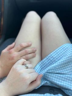 a woman laying in the back seat of a car with her hand on her leg