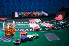 a blackjack casino table with chips and a glass of whiskey