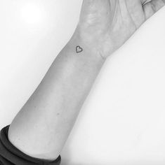 a small heart tattoo on the wrist