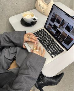 a person sitting at a table with a laptop and coffee in front of them on their lap