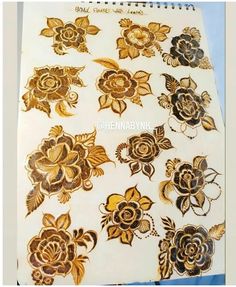 some gold and black flowers on white paper