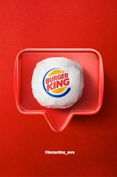 a burger king sandwich in a plastic container on a red surface with the words burger king written above it