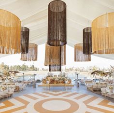 the inside of a tent with chandeliers hanging from it's ceiling and seating