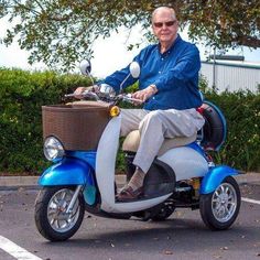 a man riding on the back of a blue and white scooter