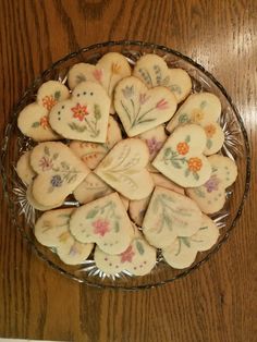 a glass bowl filled with cookies on top of a wooden table