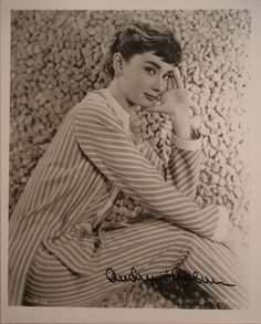 an old black and white photo of a woman sitting on the ground with her hand to her face